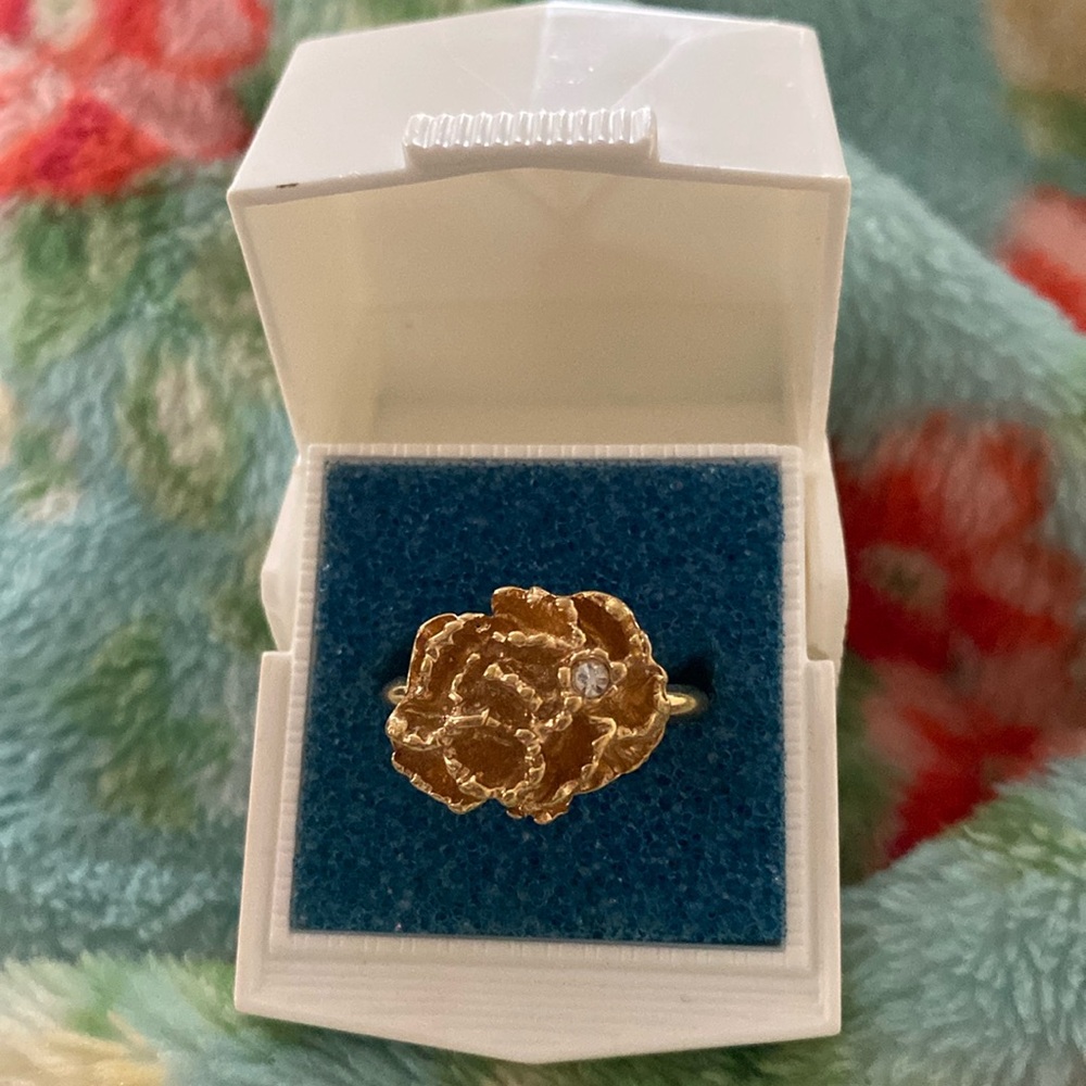 Avon gold adjustable ring. Flower with diamond accent